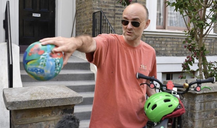 Number 10 Downing Street special advisor Dominic Cummings gestures to members of the media to observe social distancing guidelines while he holds a child's bicycle and a ball outside his home in London on May 23, 2020 after allegations he broke coronavirus lockdown rules by travelling across the country in March.