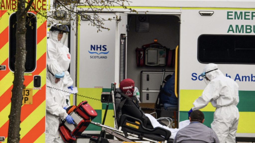 A woman with an unknown condition is helped from an ambulance at the St Thomas' Hospital on March 30, 2020 in London, England.