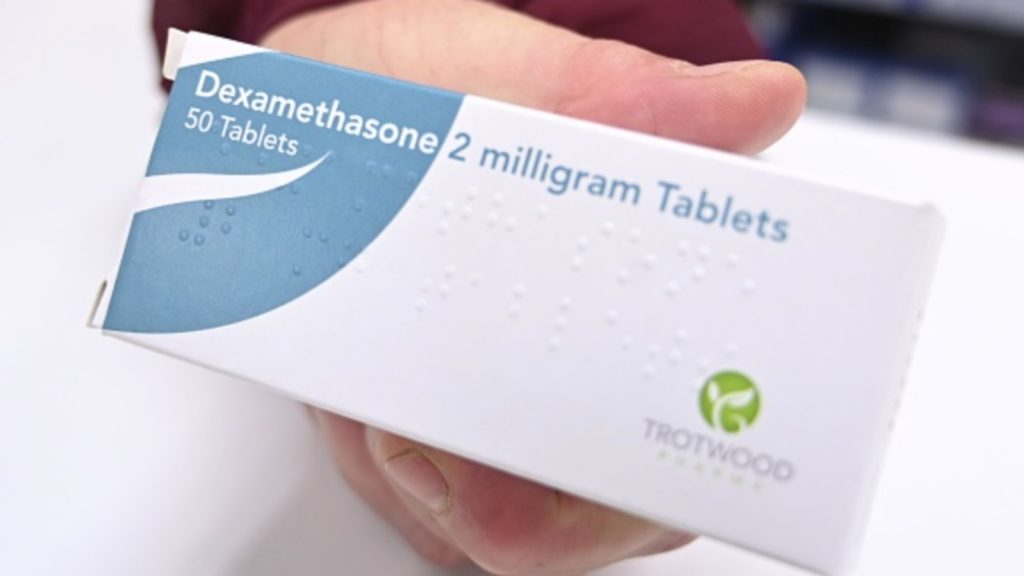 A pharmacist holds a box of dexamethasone tablets at a chemists shop in London on June 16, 2020
