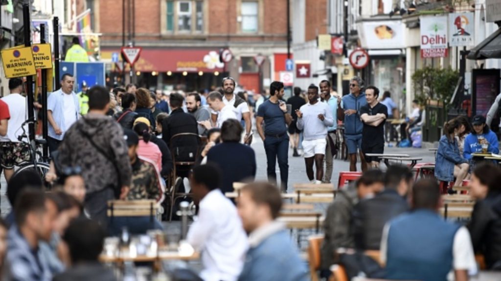 Customers sit outside re-opened bars in Soho in London on July 5, 2020, as the Soho area embraces pedestrianisation in line with an easing of restrictions during the novel coronavirus COVID-19 pandemic.